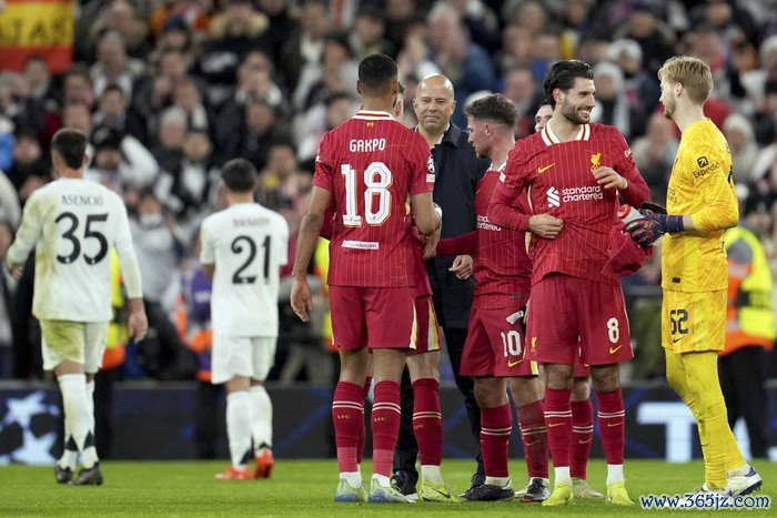 Liverpools manager Arne Slot, center, joins his players on the pitch at the end of the Champions League opening phase soccer match between Liverpool and Real Madrid at Anfield Stadium, Liverpool, England, Wednesday, Nov. 27, 2024. (AP Photo/Jon Super)