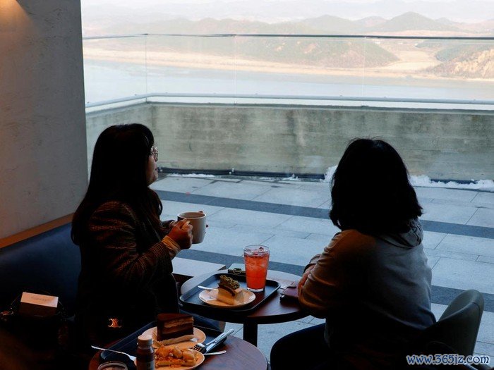 Customers queue up in front of the new store of Starbucks at the top of the Aegibong Peak Observatory, south of the demilitarized zone (DMZ), separating the two Koreas, in Gimpo, South Korea, November 29, 2024. REUTERS/Kim Soo-hyeon